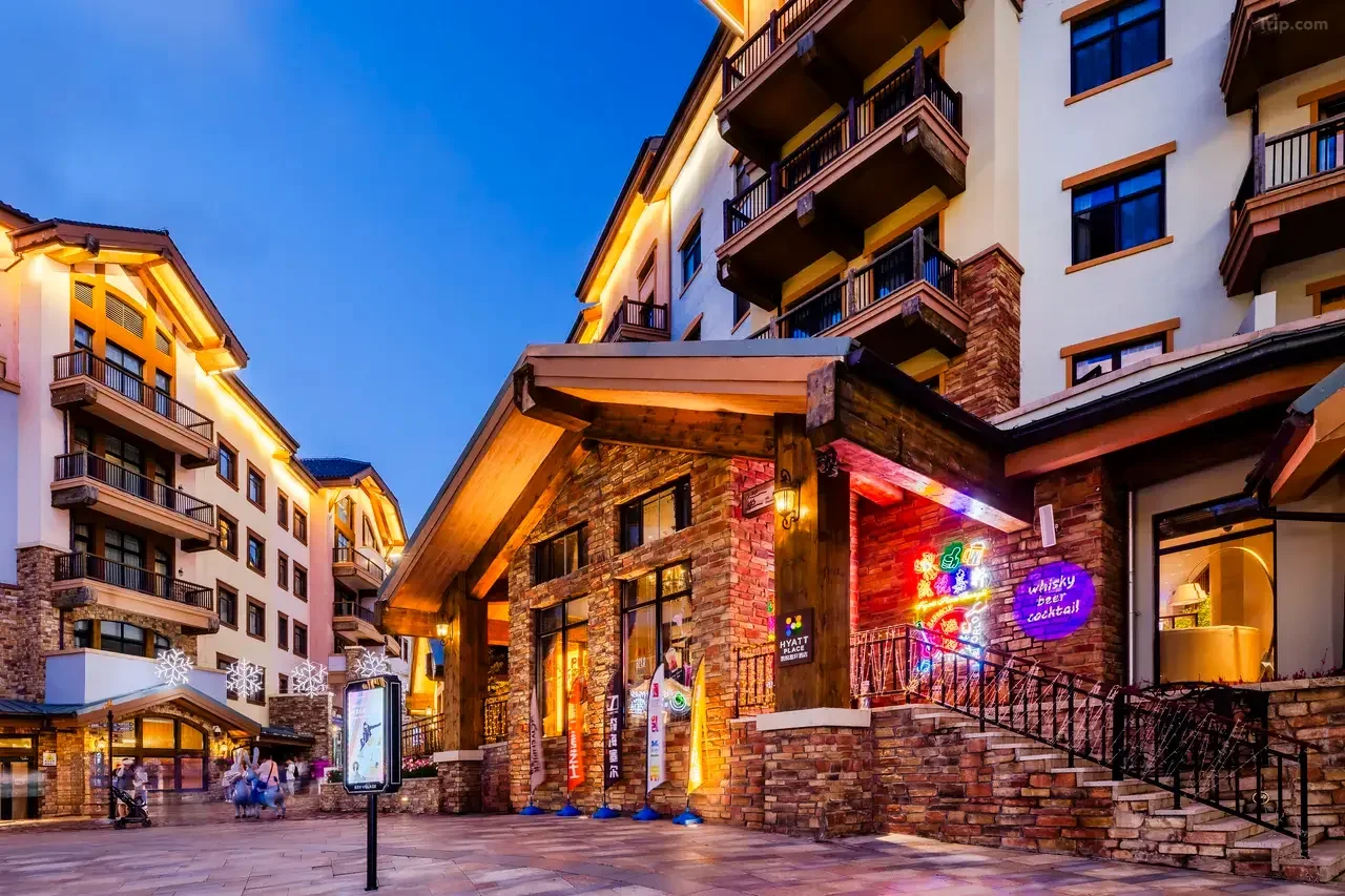 Hyatt Place hotel entrance and village street illuminated at dusk