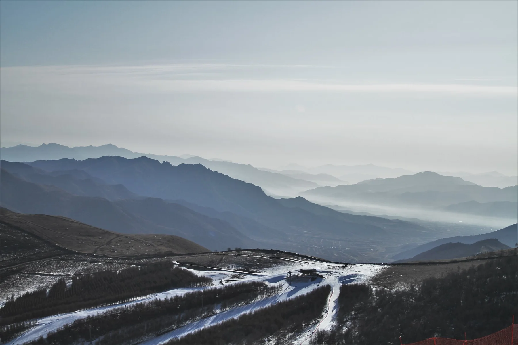 Groomed ski trails winding through the mountain ridges at Thaiwoo Ski Resort, Chongli